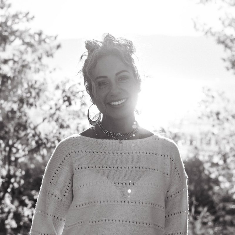 Black and white portrait of Evita smiling outdoors